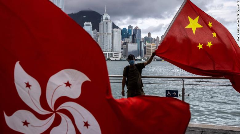 A man waves the Chinese flag to celebrate the 25th anniversary of Hong Kong&#39;s handover from Britain to China on July 1, 2022. 