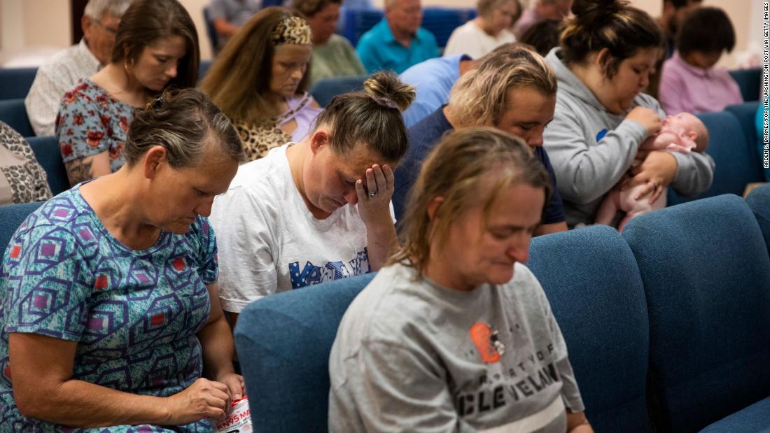 Karen Daugherty holds her head in her hands during a service at the Gospel Light Church in Hazard, Kentucky. Daugherty is staying with her family in the church, which has been set up as a shelter.