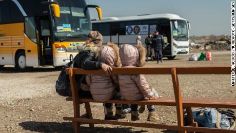 An Ukrainian mother and her daughters are seen waiting for a bus at a transit point for refugees in Palanca, south Moldova, on March 27, 2022.
