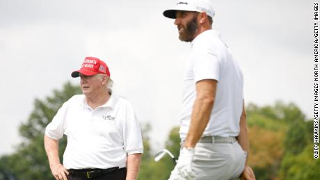 Trump looks on as Johnson plays a shot from the seventh tee during Thursday&#39;s pro-am.
