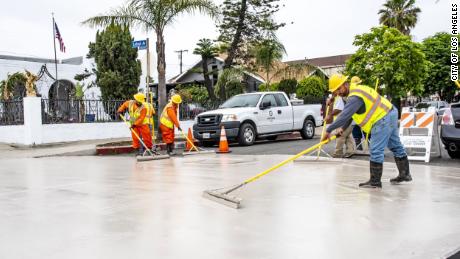 Workers paint a street to beat the heat in Los Angeles.