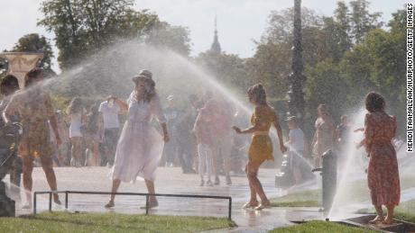 People cool down at the Jardin des Tuileries on a hot afternoon in Paris.