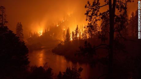 Flames burn to the Klamath River during the McKinney Fire in the Klamath National Forest northwest of Yreka, California, Sunday.