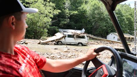 Mieszkanka Louise Turner niesie wodę znajomym i rodzinie wzdłuż zalanego strumienia Bowling Creek w Kentucky.
