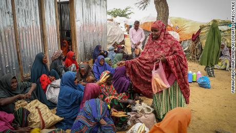 Somalis who fled drought-stricken areas receive charitable food donations from city residents after arriving at a makeshift camp for the displaced on the outskirts of Mogadishu, Somalia Thursday, June 30, 2022. 