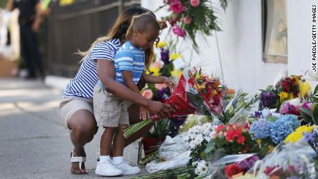 Tamara Holmes and her son, Trenton, lay flowers in front of  Emanuel AME Church after a mass shooting in June 2015 that left nine people dead.