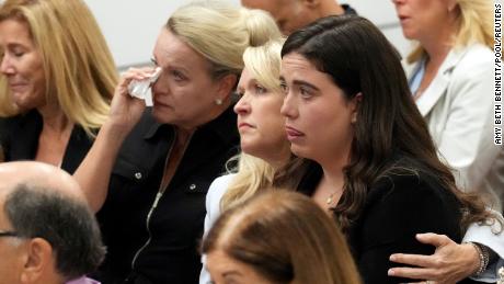 Gena Hoyer holds her daughter, Abby, as Tom Hoyer testifies about their son Luke, who was killed in the Parkland shooting. 