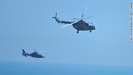 Chinese military helicopters fly past Pingtan island, one of mainland China&#39;s closest point from Taiwan, in Fujian province on August 4, 2022, ahead of massive military drills off Taiwan following US House Speaker Nancy Pelosi&#39;s visit to the self-ruled island. - China is due on August 4 to kick off its largest-ever military exercises encircling Taiwan, in a show of force straddling vital international shipping lanes following a visit to the self-ruled island by US House Speaker Nancy Pelosi. (Photo by Hector RETAMAL / AFP) (Photo by HECTOR RETAMAL/AFP via Getty Images)