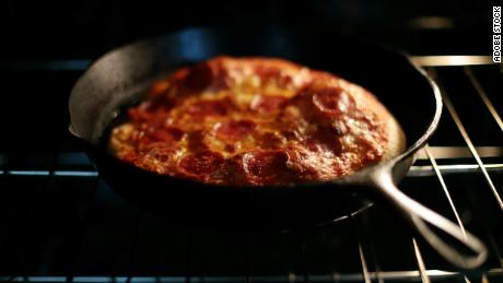 Preheating a cast iron skillet in the oven gives the dough a sizzling surface that helps the pizza puff up.