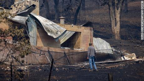 A man looks around property where a house was destroyed by the McKinney Fire in the Klamath National Forest near Yreka, California, on August 3, 2022. - At least four people are now known to have died in a wildfire sweeping through California, authorities said on August 2, as they warned the toll from the state&#39;s worst blaze this year could rise further. The fire, which is burning in the Klamath National Forest near the border with Oregon, is California&#39;s largest this year, having consumed around 56,000 acres (22,600 hectares). 
