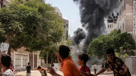 People take cover during an airstrike in Gaza City on Saturday.