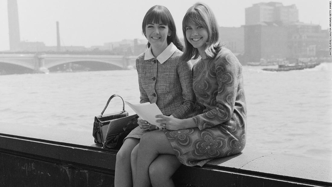 Newton-John and singing partner Pat Carroll pose for a photo in London in 1966. Newton-John recorded her first single in England in 1966 and scored a few international hits, but she remained largely unknown to US audiences until 1973, when &quot;Let Be There&quot; became a top-10 hit on both the adult contemporary and the country charts.