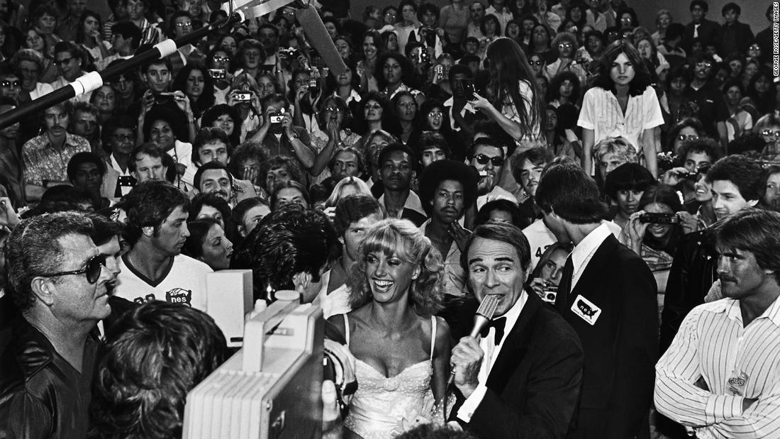 Newton-John is interviewed on the red carpet at the Hollywood premiere of &quot;Grease.&quot;