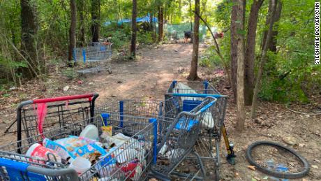 A homeless camp in Nashville is littered with shopping carts and trash.