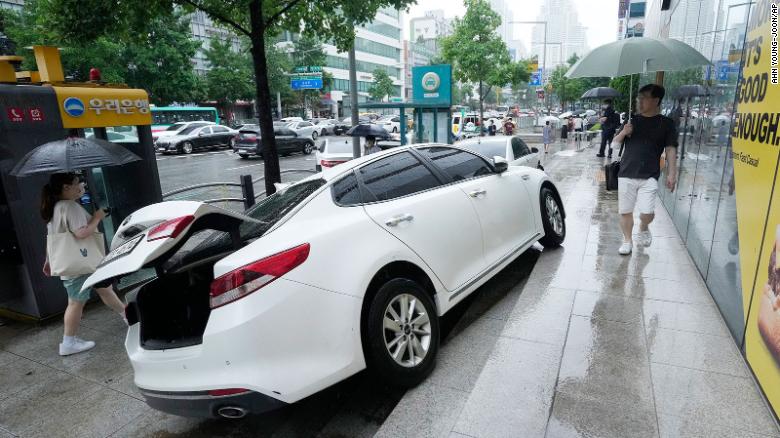 A vehicle is damaged on the sidewalk after floating in heavy rainfall in Seoul, South Korea on August 9.