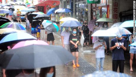 Residents line up in torrential rain for Covid testing on Aug. 8 in Sanya, 