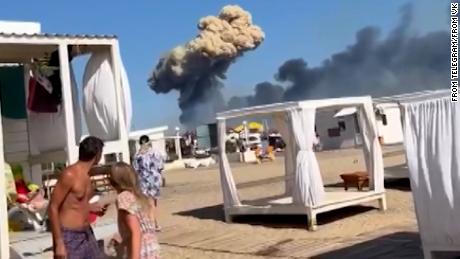 A mushroom cloud of smoke can be seen in the distance, scaring beachgoers in Crimea last week. 