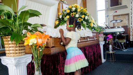 Michelle Cusseaux's 3-year-old niece looks into her casket during the funeral in 2014.