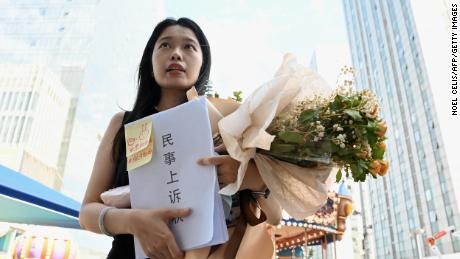 Zhou Xiaoxuan, also known as Xianzi, a feminist figure who rose to prominence during China&#39;s #MeToo movement, holds a bouquet of flowers as she arrives to attend a hearing in her sexual harassment case against prominent television host Zhu Jun at the Beijing No. 1 Intermediate People&#39;s Court in Beijing on August 10, 2022. (Photo by Noel Celis / AFP) (Photo by NOEL CELIS/AFP via Getty Images)