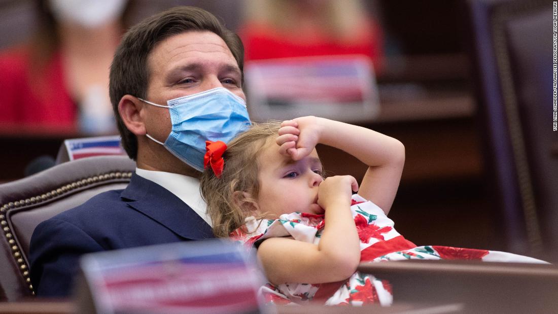 DeSantis and his daughter Madison lean back in a chair during a meeting of the Florida presidential electors in Tallahassee, Florida, in December 2020.