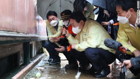 South Korean President Eun Suk-yeol visits a flooded semi-basement in Gwanak, Seoul on August 10, where a family died in the flood.