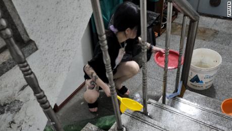8月10日，韩国首尔，一名妇女在被淹的地下室公寓里铲水。