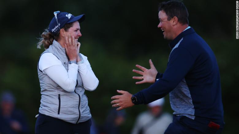 Buhai celebrates the win with her husband David on the eighteenth green.