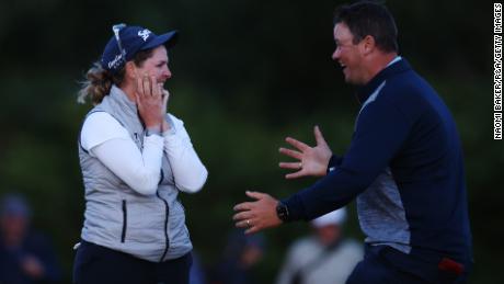 Buhai celebrates the victory with her husband David on the 18th green.