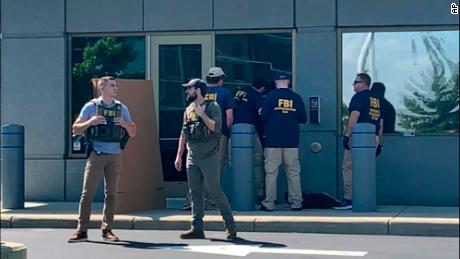 Members of the FBI gather outside the FBI's Cincinnati office after an armed man tried to break into the building.