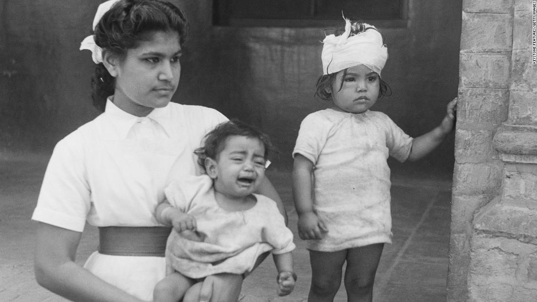 A nurse holds a crying orphaned child, as she stands beside her wounded sibling, following communal violence in Amritsar, Punjab. The children&#39;s mother was stabbed to death in March 1947 during communal riots in the months leading up to Partition. 