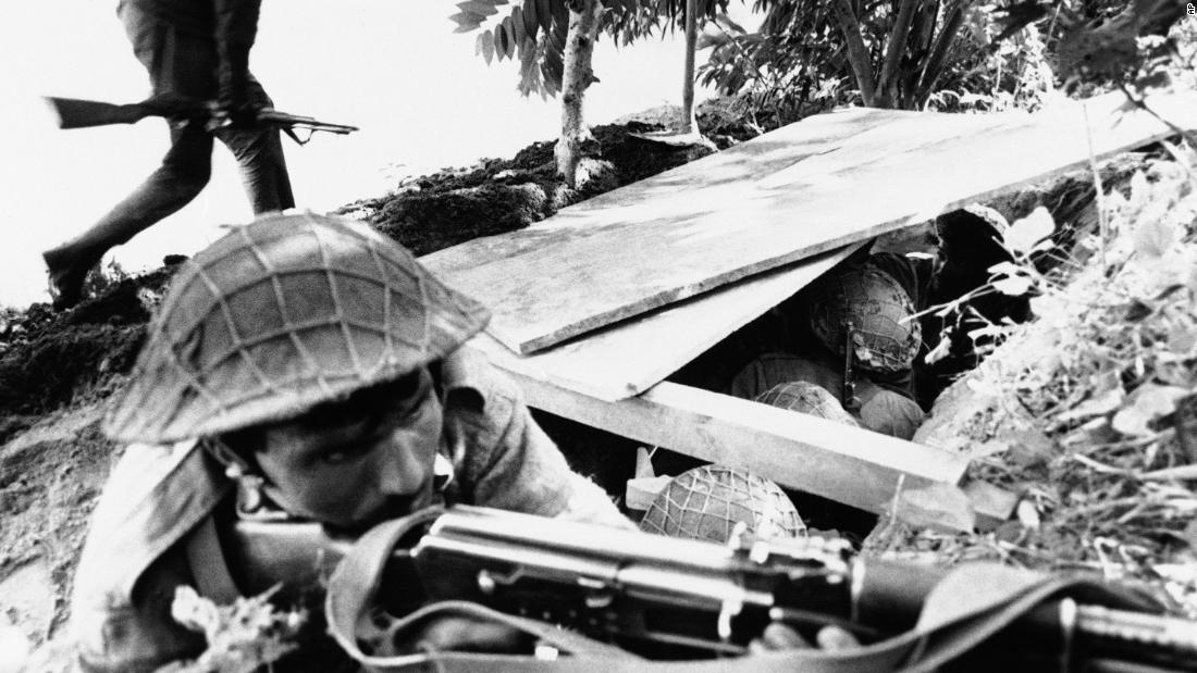 A Pakistani soldier aims his rifle, while a fellow soldier runs for cover during Indian shelling of Pakistani positions in East Pakistan on December 2, 1971. A third war between India and Pakistan in East Pakistan ends with the creation of Bangladesh.