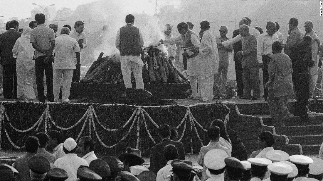 The body of assassinated Indian Prime Minister Indira Gandhi is covered with flowers on a pyre as it is set afire on November 3, 1984, after she was shot by her own security guards. 