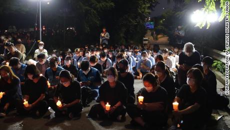Una piccola folla tiene una veglia a lume di candela a Seoul l'11 agosto per ricordare una famiglia morta quando la loro casa è stata allagata l'8 agosto.