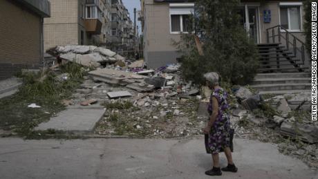 A woman assesses the damage on a street in Nikopol, where residents say they live under a relentless barrage of rockets. 