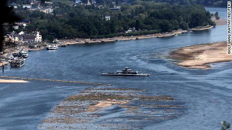 A ferry cruises past the partially dried-up river bed of the Rhine River in Bingen, Germany, August 9.