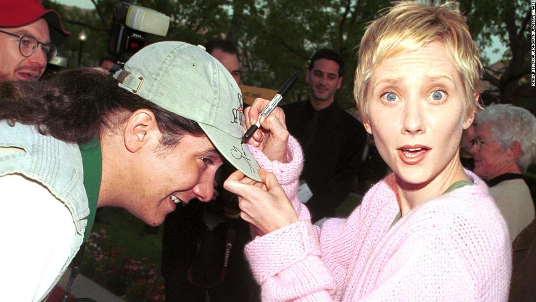 Heche signs a fan&#39;s hat at the &quot;Get Real&quot; premiere in 1999.