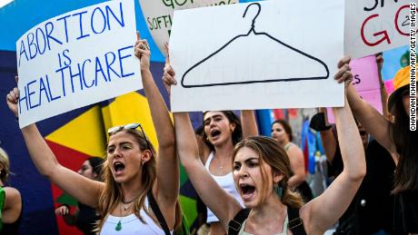 Abortion rights activists hold signs reading &quot;Abortion is Healthcare&quot; as they rally in Miami, Florida, after the overturning of Roe Vs. Wade by the Supreme Court on June 24, 2022. 