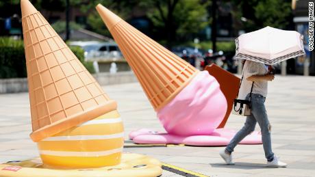 A citizen walks by ice cream-shaped installations outside a shopping mall amid a heat wave on August 2, 2022 in Hangzhou, Zhejiang Province of China.