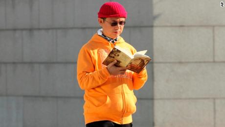 In this Dec. 2013, photo, Xiao Jianhua, a Chinese-born Canadian billionaire, reads a book outside the International Finance Centre in Hong Kong. Mystery surrounds the whereabouts of Xiao reportedly taken away from his Hong Kong hotel by mainland police, in a case that could rekindle concerns about overreach by Chinese law enforcement in the semiautonomous city. (Next Magazine via AP)