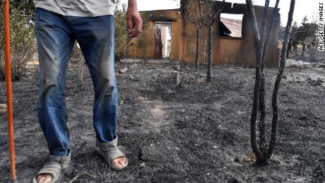 Seorang pria berjalan di depan rumahnya setelah dihancurkan oleh kebakaran hutan di kota el-Kala, Aljazair, pada 18 Agustus. Puluhan orang tewas dan banyak lagi yang terluka pada hari Rabu dalam kebakaran hutan yang melanda daerah pegunungan di Aljazair. timur.  Pihak berwenang mengatakan bahwa 2.600 hektar hancur akibat kebakaran tersebut.  