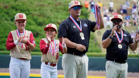 Jace Oliverson, center, father of Little Leaguer Easton Oliverson holds Easton&#39;s medal, with another son, Brogan Oliverson (6) at his side before a baseball game against Nolensville, Tennessee, at the Little League World Series on Friday. 