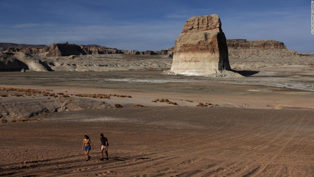People walk on an area of Lake Powell that used to be underwater at Lone Rock Beach in Big Water, Utah, on March 27.