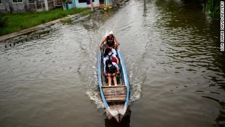 Des élèves se rendent en bateau à l'école lors de la première journée de cours en présentiel, à Macabebe, province de Pampanga, aux Philippines, le 22 août 2022.