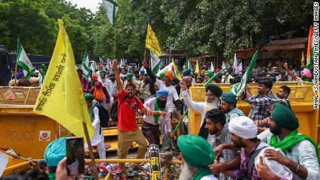 Des agriculteurs tentent de franchir les barrières lors d'une manifestation organisée par certains syndicats agricoles à Jantar Mantar le 22 août 2022 à New Delhi, en Inde.