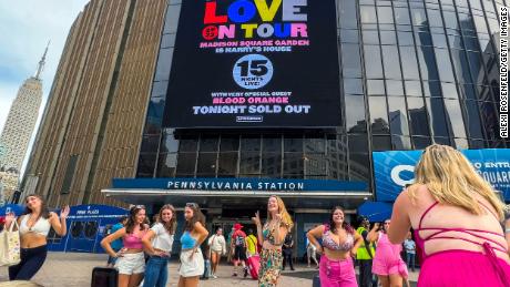 Fans wear themed outfits and take photos outside Madison Square Garden before the Harry Styles 