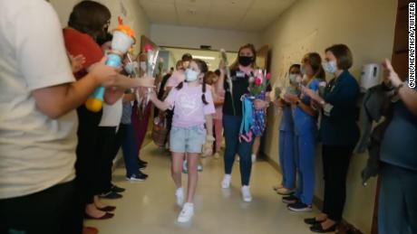 Mayah Zamora was hospitalized for 66 days after the shooting. Here, she hands roses to nurses and other staff as she leaves San Antonio's University Health hospital July 29.