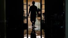 A relative walks through the Peach Tree Village nursing home to collect family belongings after the facility was flooded Wednesday.