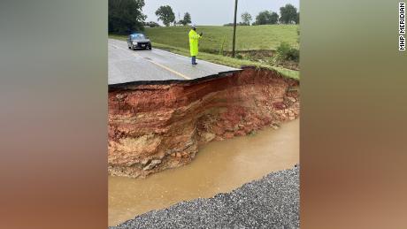 A train is derailed and roads are washed away after torrential rains ravage parts of Mississippi