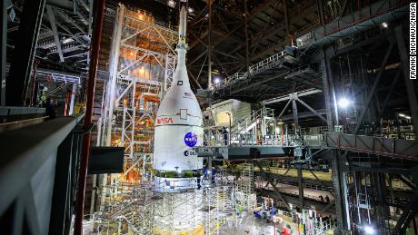 The Orion spacecraft for NASA&#39;s Artemis I mission, fully assembled with its launch abort system, is lifted above the Space Launch System rocket at the Kennedy Space Center in Florida on Oct. 20, 2021. 