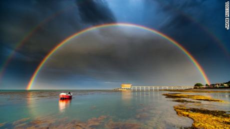 After chasing storms and showers west to east across the Isle of Wight to capture some incredible rainbows, Jamie reached Bembridge as the final shower left. &quot;In a panic (he) waded into the waist-deep water, fully dressed, just to compose this scene&quot;. Rainbows are optical phenomena that occur when sunlight shines through raindrops. The light is refracted as it enters the raindrop, then reflected off the back of the droplet and then refracted again as it exits and travels towards our eyes. This causes the sunlight to split into different colours. The sun needs to be behind the viewer and needs to be low in the sky. The lower the sun in the sky, the more of an arc of a rainbow the viewer will see. Also, the rain, fog, or other source of water droplets, must be in front of the viewer. The angle at which the light is scattered is different for everyone, which means that every rainbow is unique to the observer. Double rainbows form when sunlight is reflected twice within a raindrop. They are relatively common, especially when the sun is low in the sky, such as in the early morning and late afternoon. The second rainbow is fainter, and more &#39;pastel&#39; in tone and a key feature of a double rainbow is that the colour sequence in the second rainbow is reversed. 